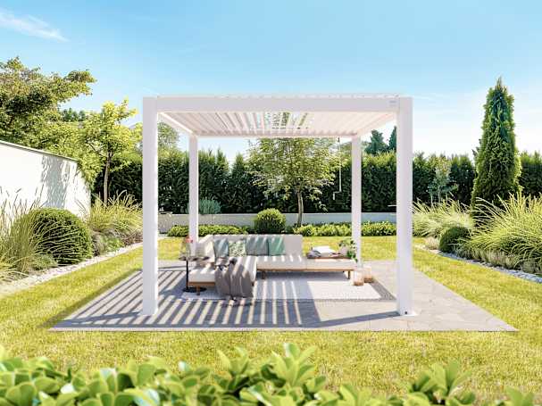 White louvered pergola positioned in a landscaped garden with outdoor lounging furniture