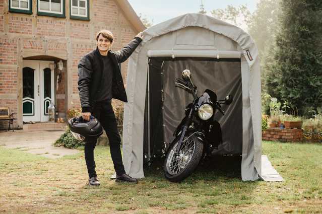 Portable garage shelter with motorcycle, protecting vehicles during autumn weather