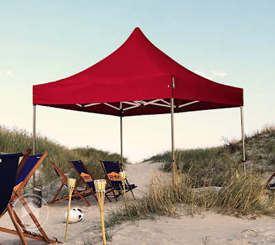 Red pop-up canopy sheltering beach chairs at a beach