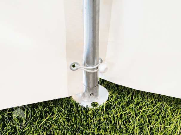 Wide steel foot plate and galvanized tent leg of a 20×20 high peak frame tent secured on grass